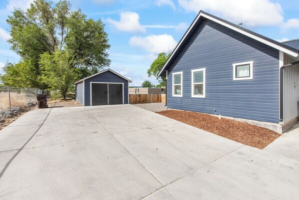 A residential property with a garage, a covered patio, and a fenced yard.