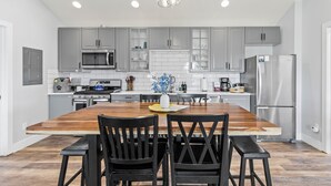 A modern kitchen with grey cabinets, a wooden dining table, and black chairs. - Pet & Family Friendly, Mountain Views, Downtown Montrose 20 Min to National Park (Montrose)