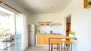 Una cucina moderna con isola centrale, frigorifero e zona pranzo con sedie.