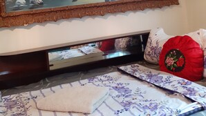 A bedroom with a bed, a painting of a winter landscape, and a red pillow. - Traditional Camping ,Romania (Roșia Montană)