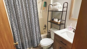 Une salle de bain équipée d’une douche, de toilettes, d’un lavabo et d’un porte-serviettes.