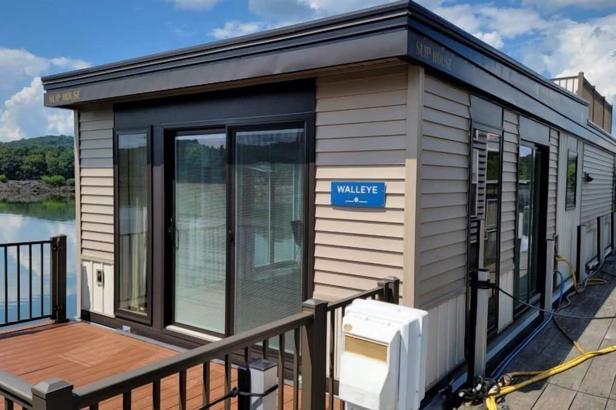 A slip house with a deck, large sliding glass doors, and a sign indicating 'WALLEYE'.