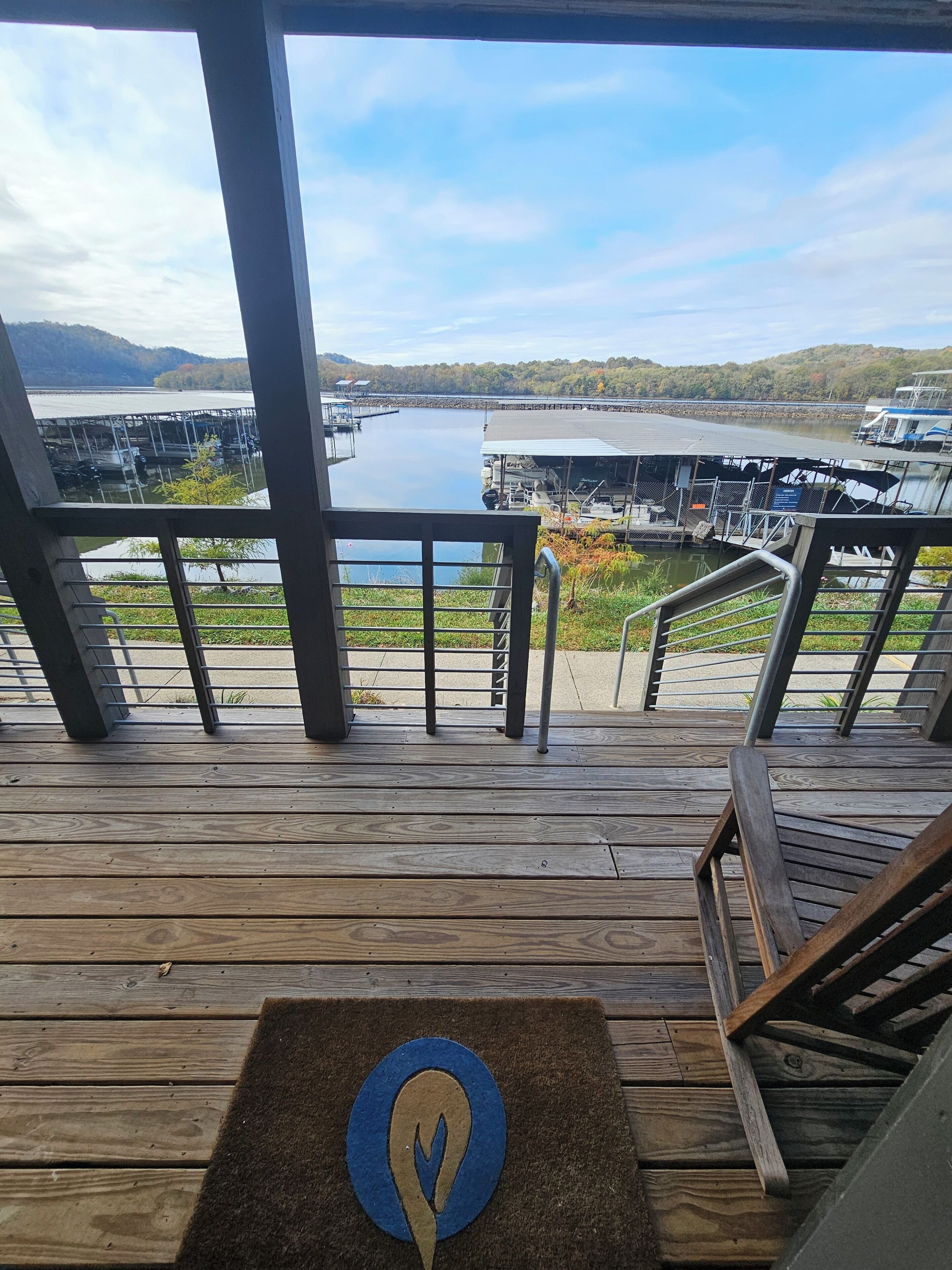 A wooden deck with a view of a marina and a body of water.