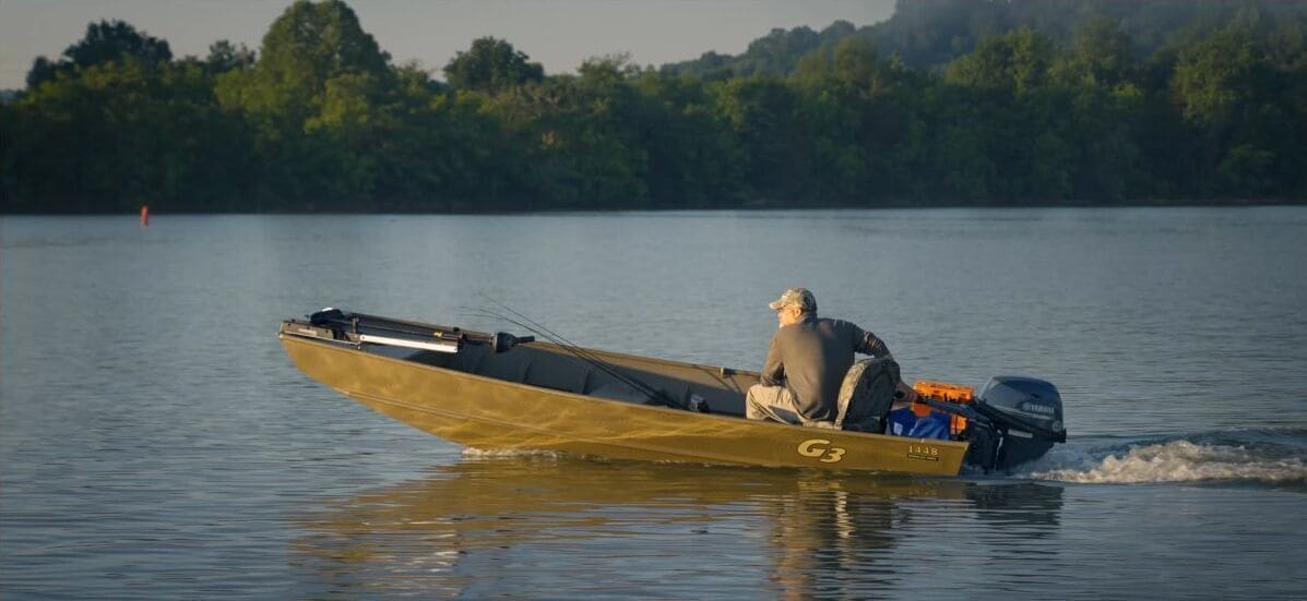 A small boat with a person on it, moving on calm water.
