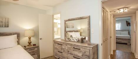 A bedroom with a bed, dresser, and a ceiling fan.