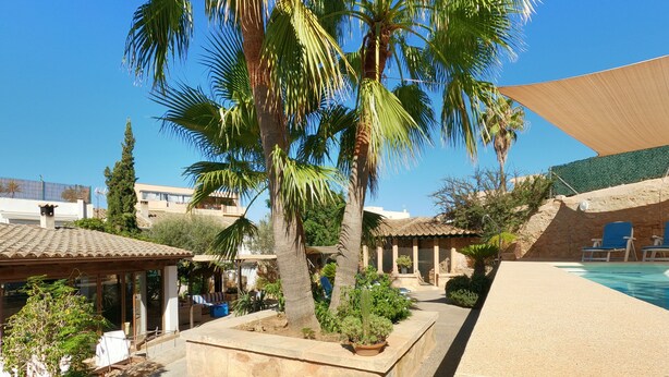 A poolside area with a covered seating area, palm trees, and a stone wall. - VILLA MARIA, NEAR PALMA BEACH (Sant Jordi, Palma)