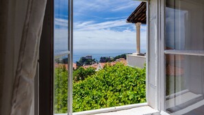 Vista dalla finestra su cielo sereno e costa lontana.