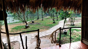 Una escalera de madera que conduce a un espacio cubierto con vista a un lago y árboles.