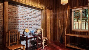 Habitación con pared de ladrillo, muebles de madera y ventana con vistas a la vegetación.