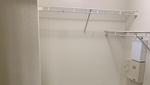 A small, carpeted closet with a metal shelf and a telephone interface box. - Apartment w/ Pool view 5 min from Galleria (Houston)