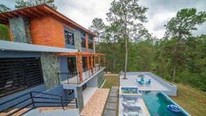 A modern two-story house with a swimming pool, outdoor seating, and a stone pathway. - VILLA SEGURA VICENTE (Constanza)