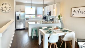 A modern kitchen with white cabinets, stainless steel appliances, and pendant lighting. - Skyline Views/3 Miles to Downtown/WeeklyDiscounts/Pet Friendly (Nashville)