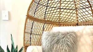 A wicker chair with a cushion and a fluffy pillow, a potted plant, and a fluffy rug on the floor. - Skyline Views/3 Miles to Downtown/WeeklyDiscounts/Pet Friendly (Nashville)