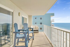 Enjoy the ocean view from this balcony with a table, chairs, and sofa.