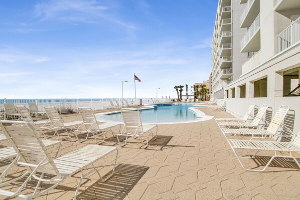 Relax by the oceanfront pool surrounded by comfortable lounge chairs.