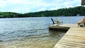 A wooden dock extending into a lake with clear skies. - Sunset Retreat Lake Rosseau  (Rosseau)