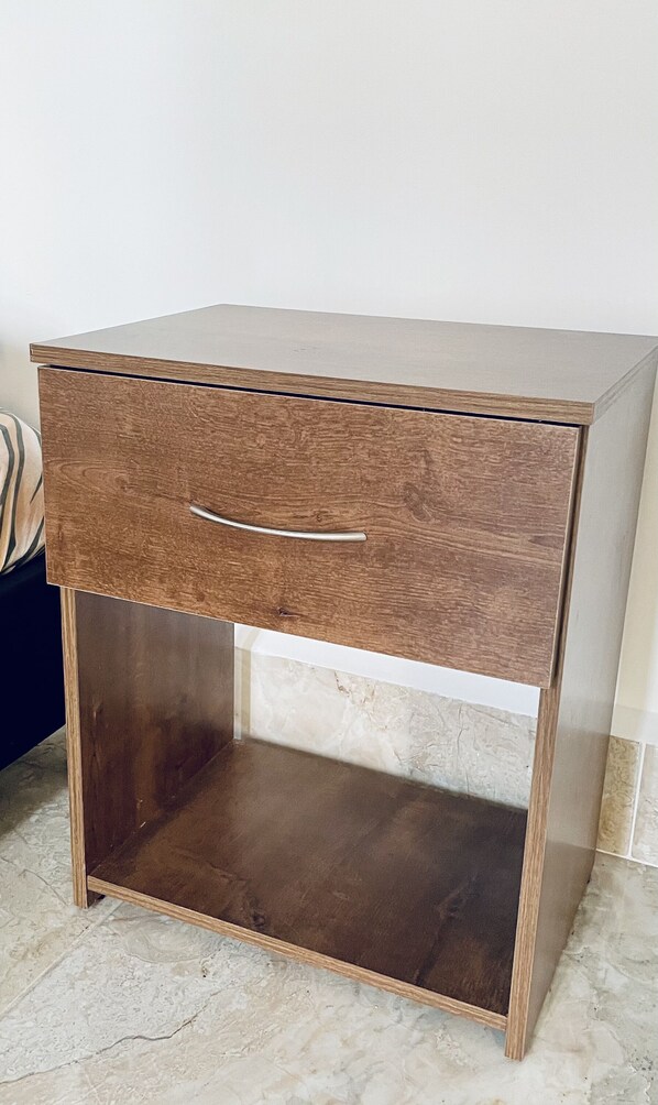 A wooden nightstand with a drawer and a lower shelf.