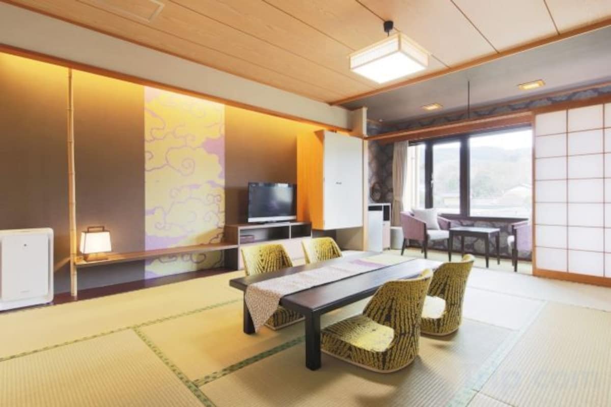 A traditional Japanese-style room with tatami flooring, a low table, and chairs.