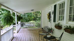 A wooden porch with a white railing, two metal chairs, and potted plants. - Pet Friendly Quiet Retreat Near Nashville (Kingston Springs)