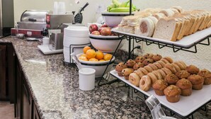 A buffet setup with various food items including fruits, bread, muffins, and pastries. - Comfort Inn Bristol (Bristol)