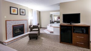 A hotel room with a fireplace, a TV, a microwave, and a small seating area. - Comfort Inn Bristol (Bristol)
