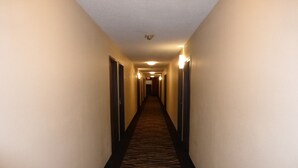 A hotel hallway with carpeted floors and doors on both sides. - Red Roof Inn Bristol (Bristol)