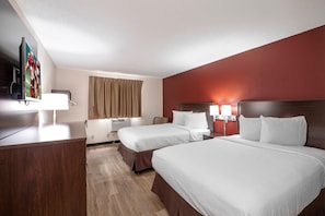 A hotel room with two beds, a desk, a television, and a window with curtains. - Red Roof Inn Bristol (Bristol)