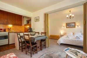 Quarto de hotel compacto com cozinha compacta, área de refeições e cama.