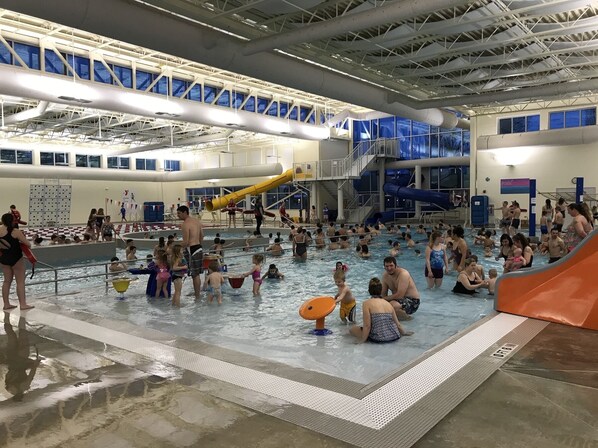 Swimmers can enjoy multiple lanes and water slides in this pool area.