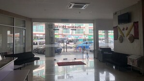 A hotel lobby with a glass wall, a reception desk, and a seating area. - Permai Hotel Sibu (Sibu)