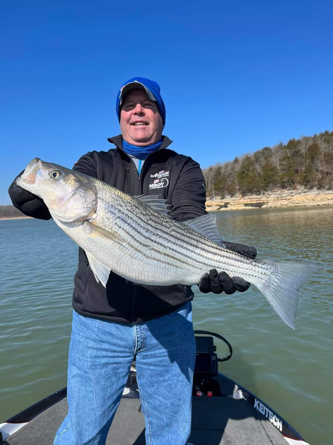 A person holding a fish on a boat.