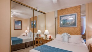 Ein Hotelzimmer mit einem großen Bett, zwei Nachttischen mit Lampen, einem Spiegel und einem gerahmten Bild an der Wand.