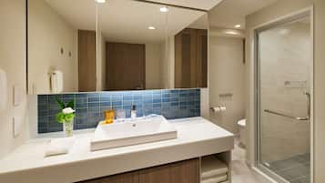A modern bathroom with a large mirror, a sink, and a shower area.
