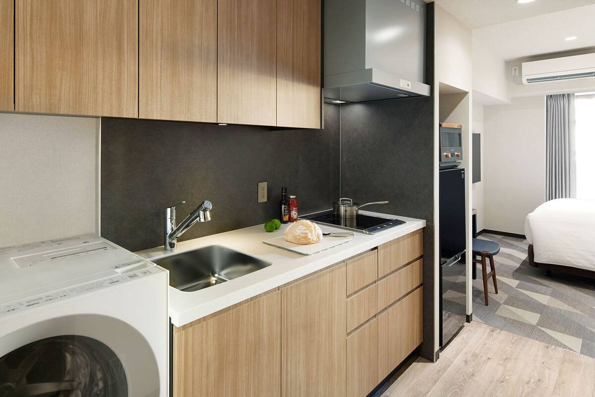 A compact kitchen with a washing machine, a sink, and a small countertop.