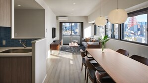 Een moderne keuken met een geïntegreerde spoelbak en een eethoek met een houten tafel en stoelen.