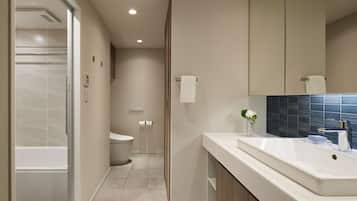 A modern bathroom with a bathtub, toilet, and sink.