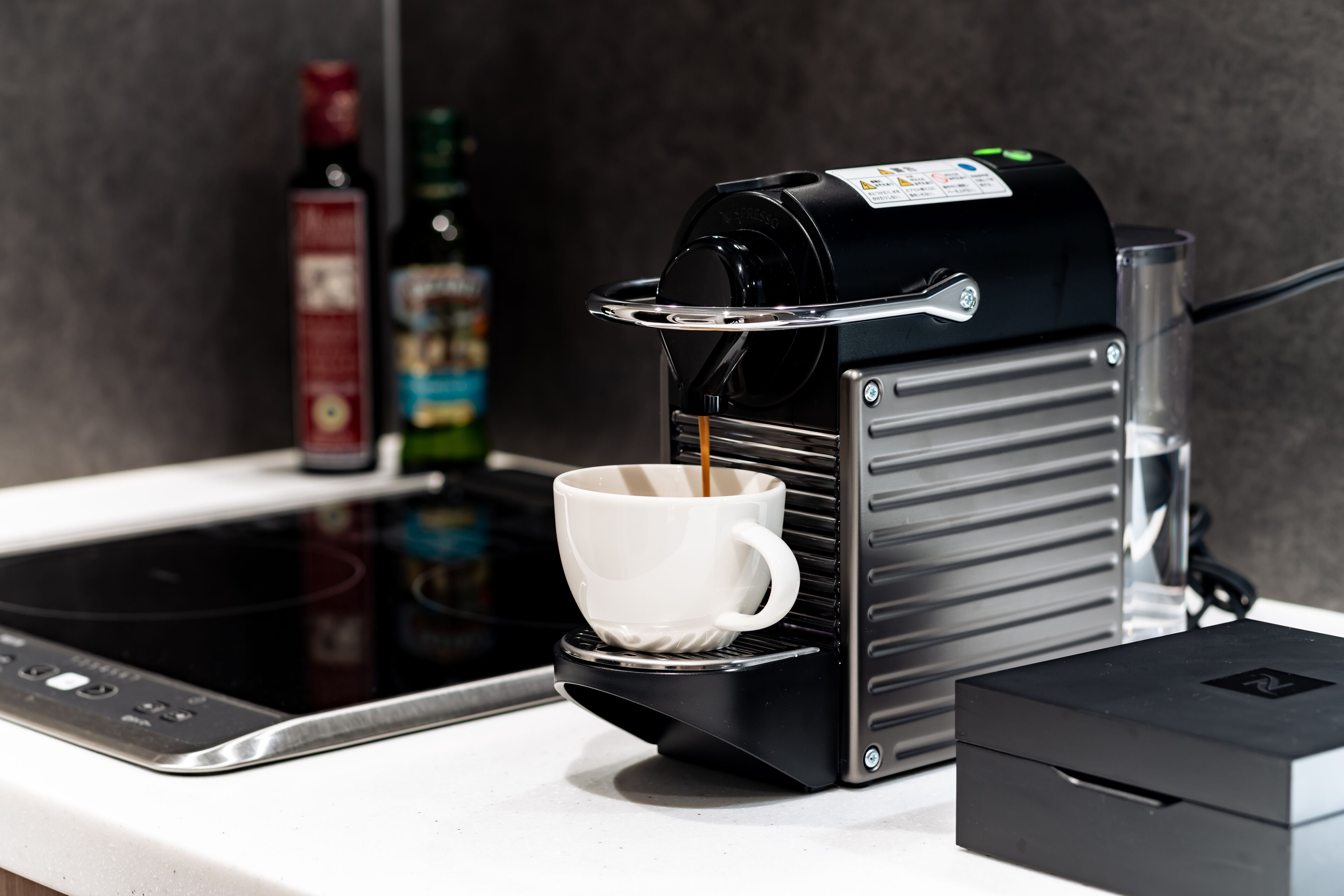 A coffee machine dispensing coffee into a cup on a kitchen counter.