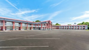 A motel with a large parking lot, multiple-story buildings, and a red roof. - Red Roof Inn Berea (Berea)