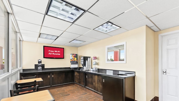 A hotel lobby with a kitchenette area, a coffee machine, and a sign indicating free Wi-Fi in all rooms. - Red Roof Inn Berea (Berea)
