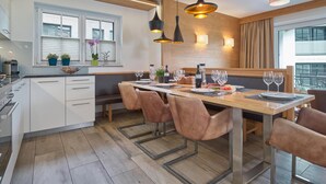 A modern kitchen with a central island, pendant lighting, and a view of the city.