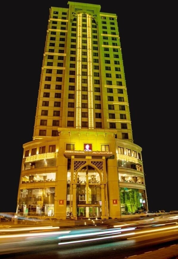 Ein hohes Hotel mit mehreren Etagen, einem markanten Eingang und einer gut beleuchteten Fassade.