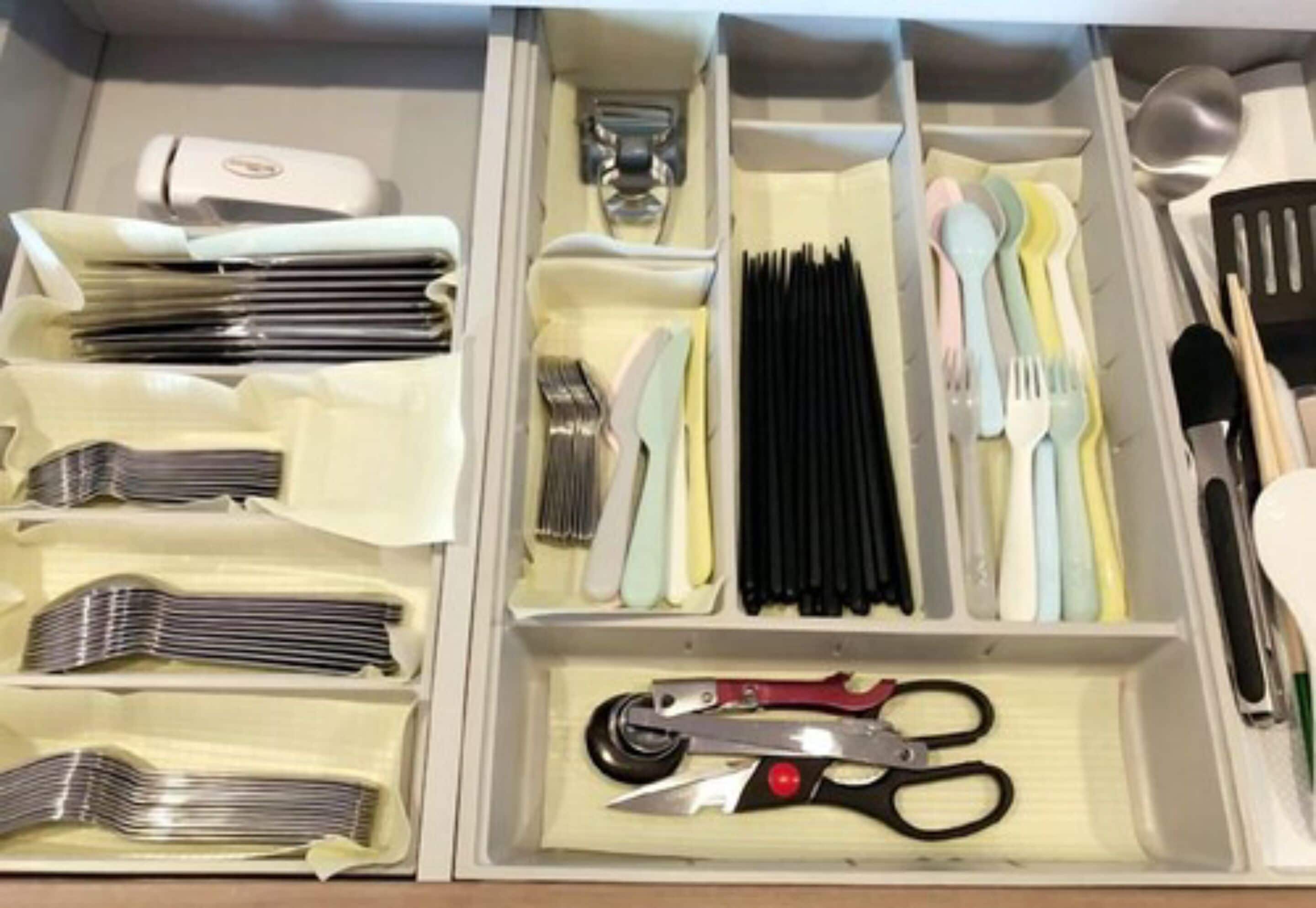 A drawer with neatly organized utensils including forks, knives, and spoons.