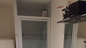 Ett badrum med ett vitt handfat, en duschkabin med glasväggar och en vit toalett.