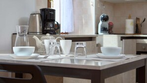 Eine Küche mit Kaffeemaschine, Wasserkocher und Teekanne auf der Arbeitsfläche.