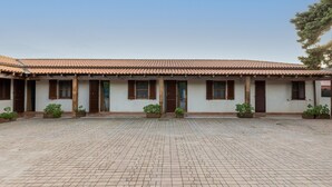 A building with a tiled roof, multiple windows with shutters, and potted plants in front. - Holiday Home ‘Residenza Solemar - App 14’ with Sea View, Wi-Fi (Bosa Marina)