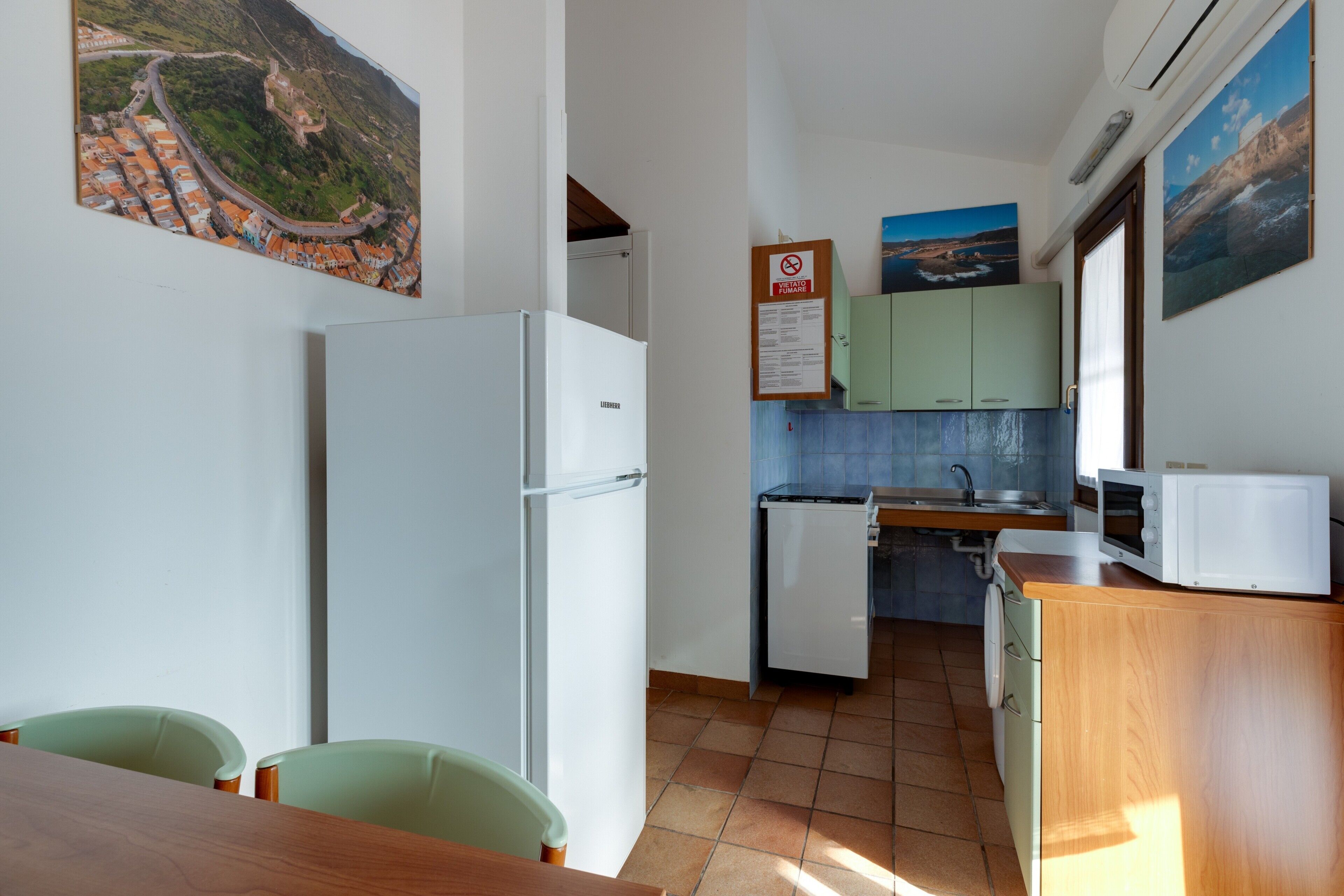 Una cucina compatta con frigorifero, microonde e lavandino.