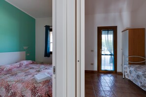 Un dormitorio con cama, armario y puerta que da a otra habitación.