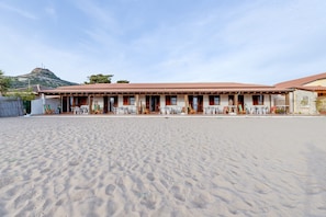 A building with a tiled roof, multiple windows, and a flat roof terrace with outdoor seating. - Holiday Home ‘Residenza Solemar - App 13’ with Sea View, Wi-Fi, A/C (Bosa Marina)