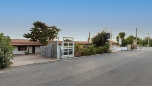 A street view with a house, a gate, and a clear sky.