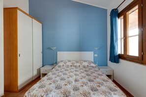 Una camera da letto con un letto, un armadio, comodini e una finestra con tende.